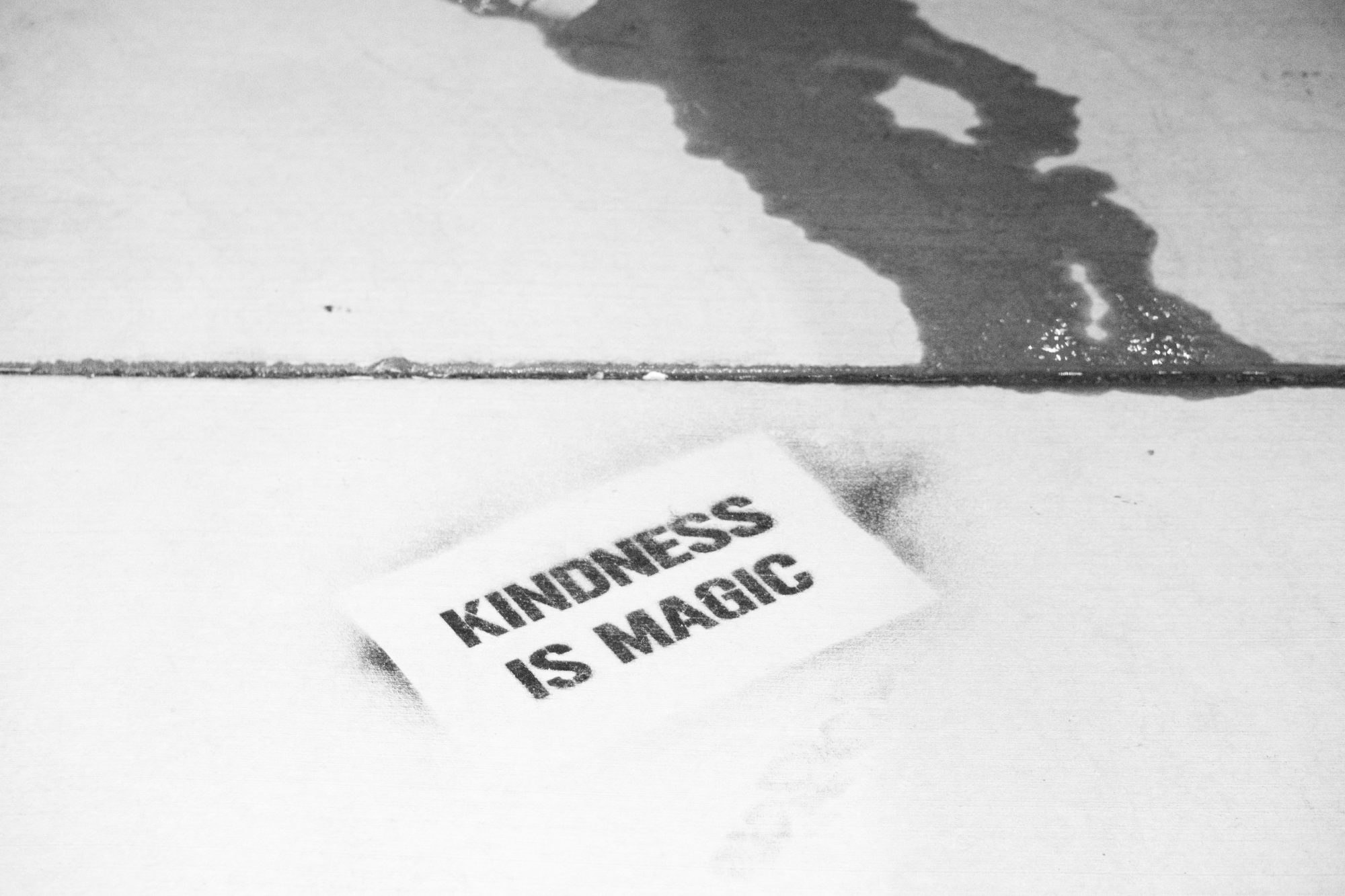 Un papier sur un sol avec dessus le texte Kindness is magic